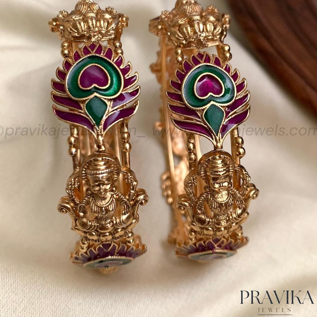 Gold earrings with green and purple design on a white background, branded 'Pravika'.