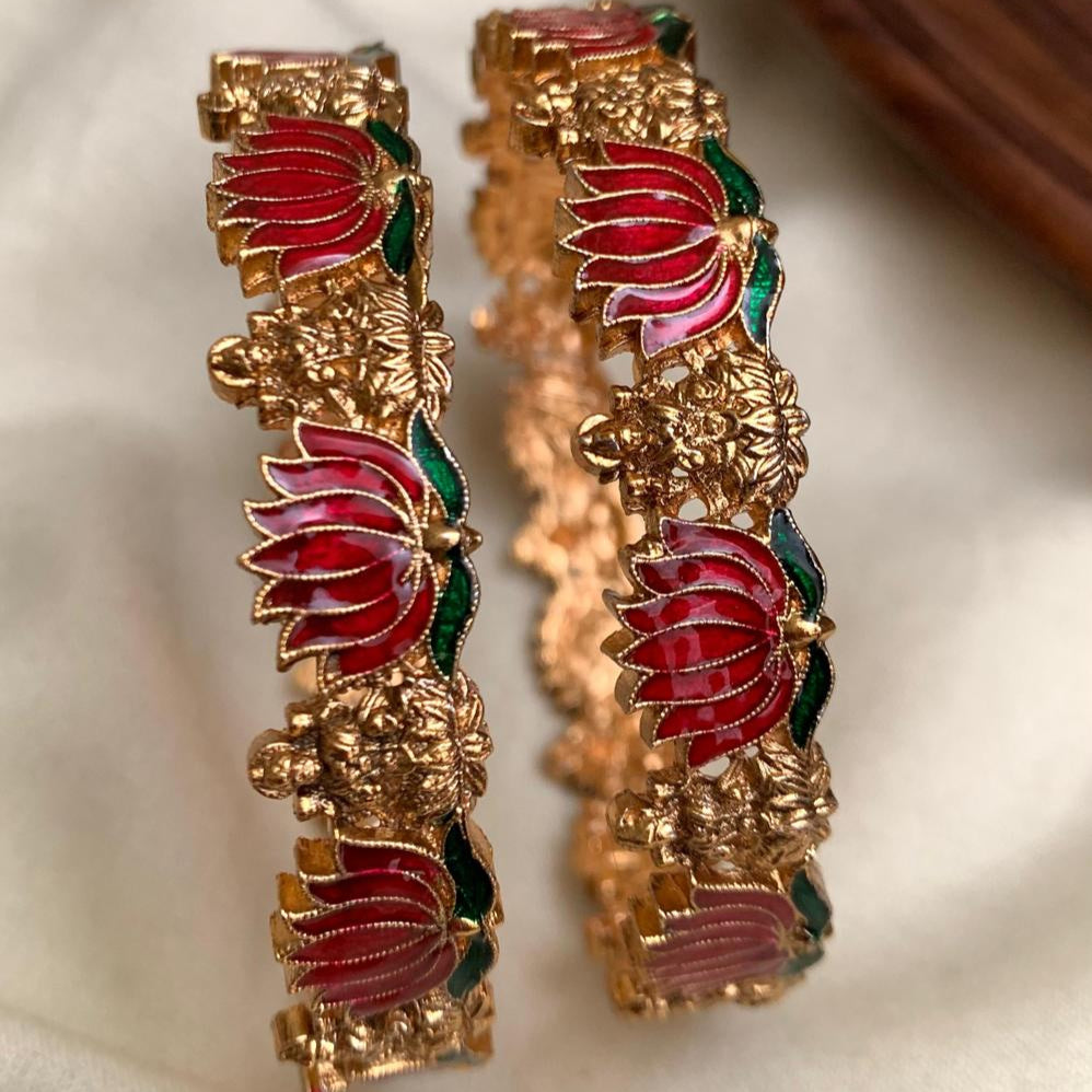 Pair of gold and red earrings on a light background