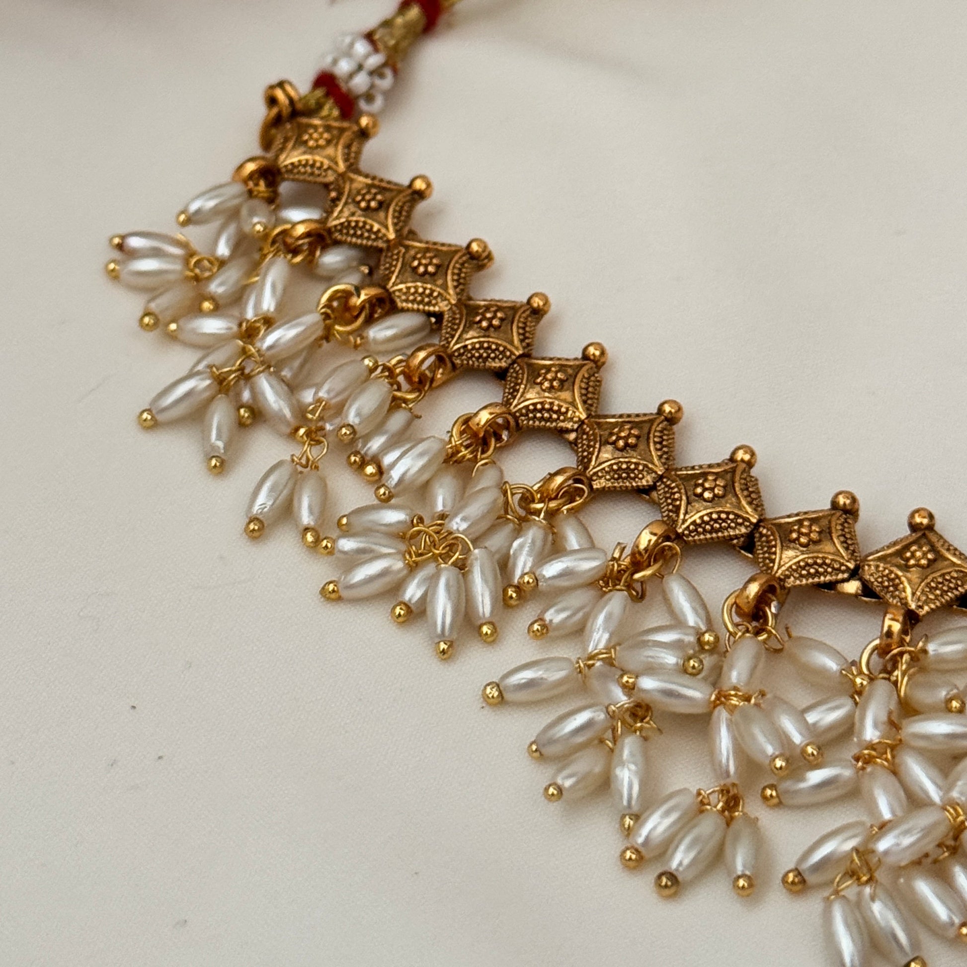Gold and pearl necklace on a white background