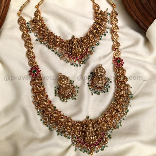 Gold necklace and earrings set on a white fabric background