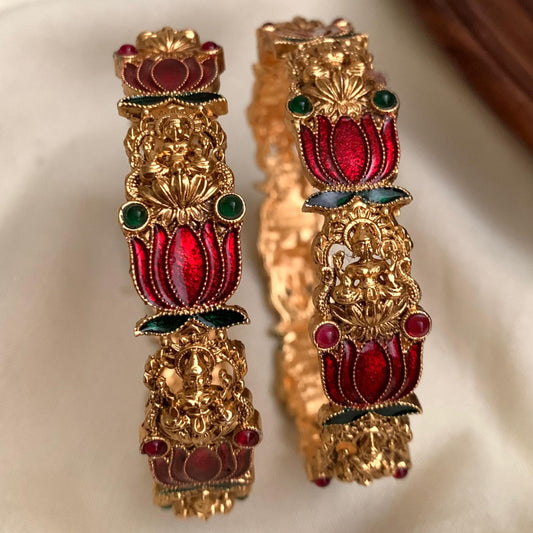Ornate gold and red earrings on a beige fabric background