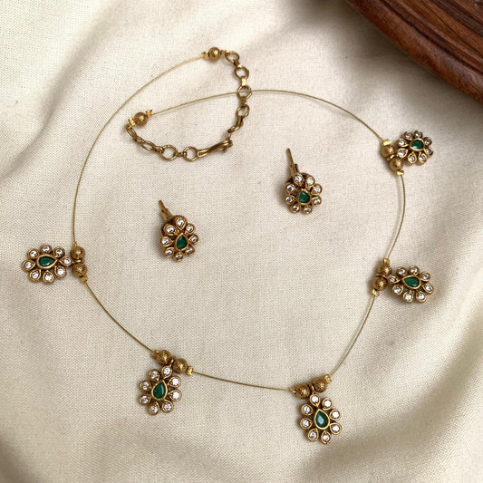 Jewelry set with necklace, earrings, and ring on a beige fabric background